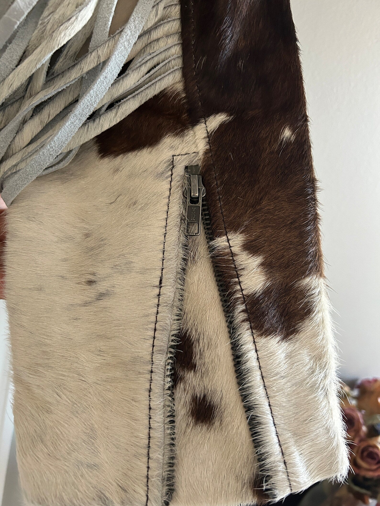 Hair-on cowhide fringe jacket women's edition with a cropped cut, full back tassels, and zip front—bold cow print jacket that makes a statement.

