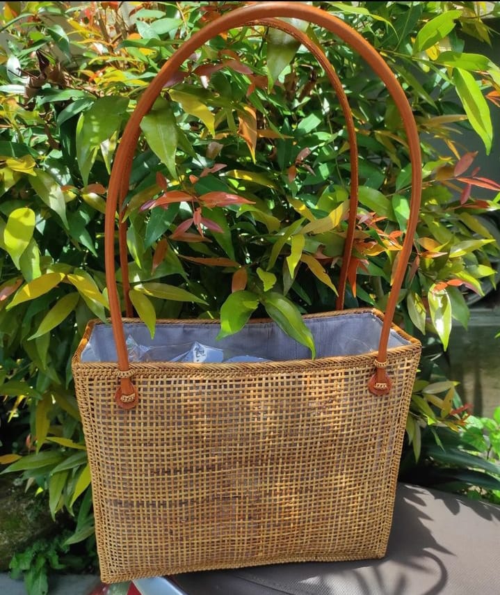 Elegant and versatile rattan tote featuring sturdy handles, perfect for everyday use. Add a touch of nature-inspired charm to your outfit with this woven bag.