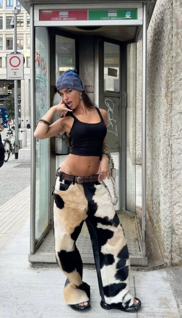 Women’s cowhide pants with real black and white cow fur and leather back. Bold cow girl outfit for western styling, rodeo events, or country streetwear.