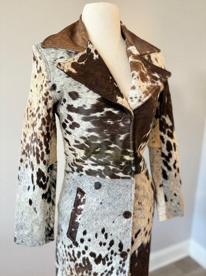 Unique cow skin coat featuring natural black, brown, and white tones. Western trench coat design ideal for ranch wear and rodeo.
