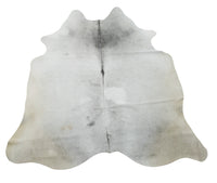 A handcrafted cow skin rug in a soft and rich light grey white with bring a touch of luxury to your living room