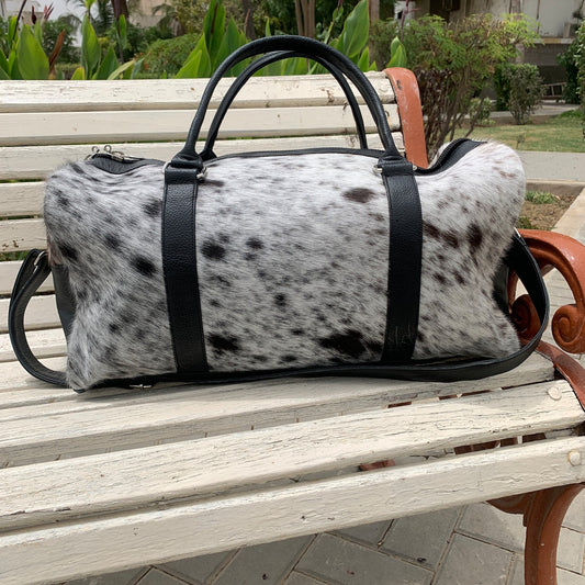 Elevate your escapades with this cow skin weekender bag, a symbol of wanderlust and refined taste for the modern traveler.
