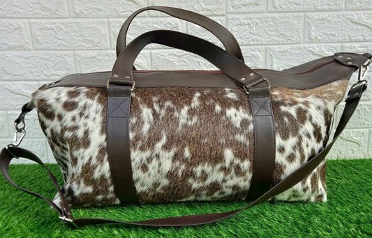 Make a stylish statement with this exotic cowhide travel bag! Roomy and luxurious, it is perfect for carrying all your essentials in style.