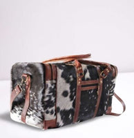 Travel in style with this unique, one-of-a-kind cowhide luggage bag! Its timeless design and luxurious quality are sure to make a statement on your next journey.