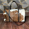 This stylish cowhide duffle purse is perfect for any event or trip - it's easy to carry and features a spacious main compartment, plus an interior pocket for extra organization.