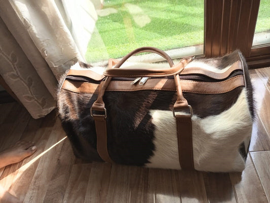 Experience luxury travel with this cow skin weekender bag, designed for your adventures.