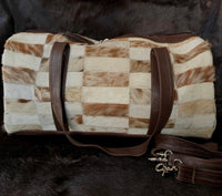 This luxurious light beige cowhide patchwork travel bag is crafted with premium quality leather and features a modern design. Carry it on your next adventure in style!