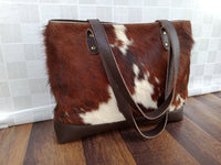 The perfect blend of texture and color makes this cow hide bag an eye-catching accessory that is sure to draw attention wherever you go.