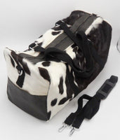 The spacious main compartment is perfect for storing clothes, shoes, and other belongings, while the smaller front pocket is perfect for holding your passport and other valuables. The cowhide bag also features two handles and an adjustable shoulder strap for carrying comfort.