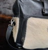 Satisfy your wanderlust with this cowhide overnight bag, a testament to timeless style and practicality for the seasoned traveler.