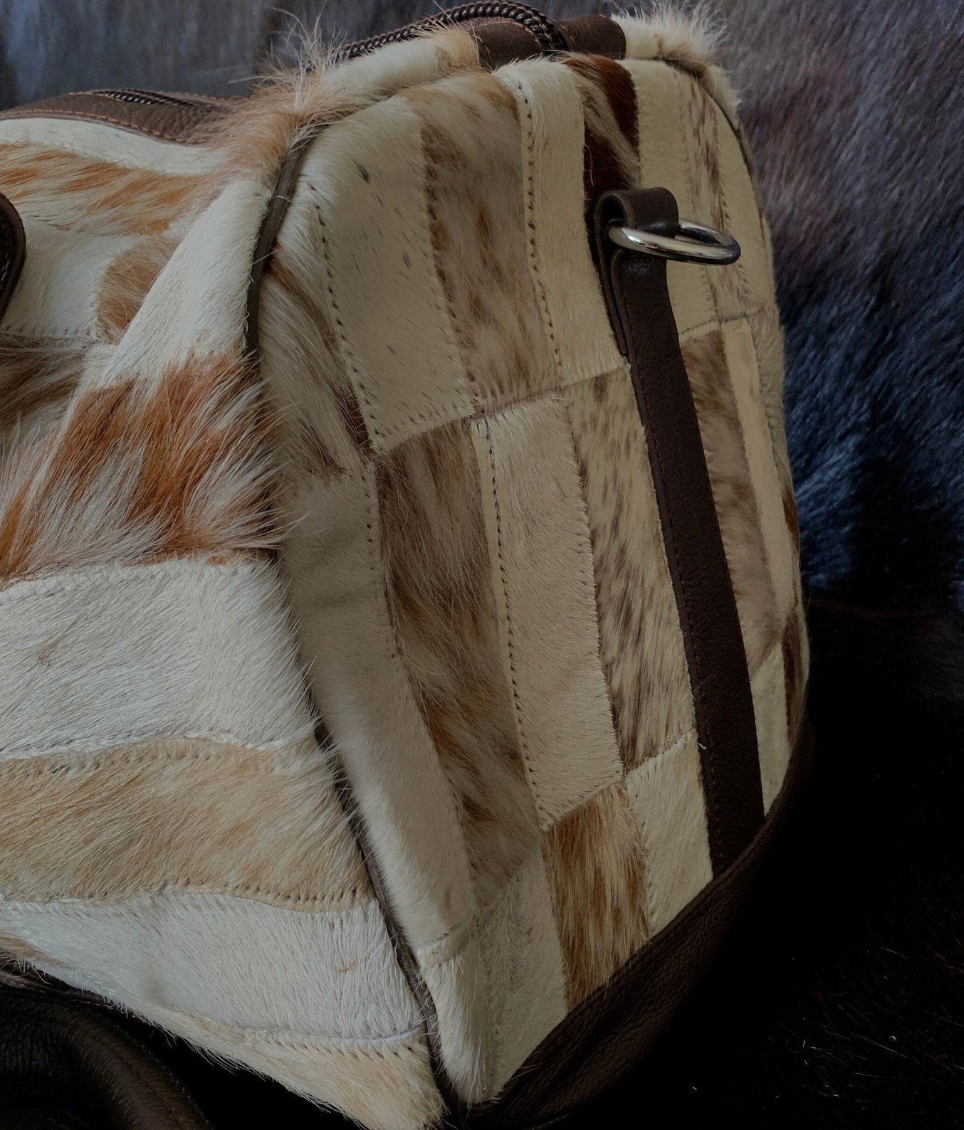 Travel with flair using this cowhide travel bag, a perfect blend of durability, style, and functionality for the modern voyager.