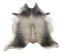 A grey cowhide rug Brazilian in a ranch living room plays a major part in the design of a space, soft, smooth and there is no need for anything underneath. 