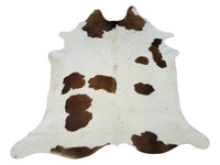 Transform your living space with this luxurious natural cowhide rug in a warm brown and white combination. Add a touch of elegance and comfort to any room.