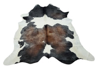 While decorating a modern living room or farmhouse kitchen cowhide rug natural tricolor in a mix of brown, black and white will transform the room