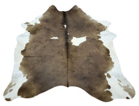 A brown and white cowhide rug can add a touch of rustic elegance to any room. The natural beauty of the hide, soft and smooth to the touch, can make any space feel warm and inviting.