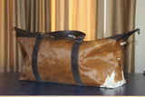 Unleash your adventurous spirit with this cowhide duffle bag, crafted to accompany you on your wildest escapades.