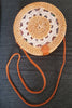 Boho rattan purse with a delicate weave and compact design, placed on a minimalistic white background.