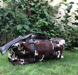 Cowhide duffle bag wholesale with leather strap and zipper one of its kind reddish brown, black and white.