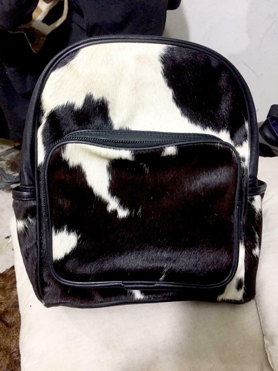 Detailed close-up of a cowhide backpack, highlighting soft fur texture, durable stitching, and quality craftsmanship.