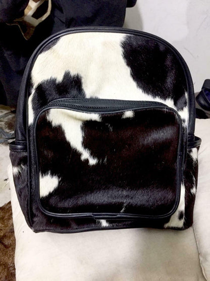 Detailed close-up of a cowhide backpack, highlighting soft fur texture, durable stitching, and quality craftsmanship.