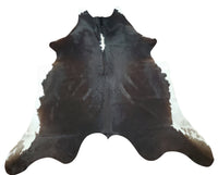 Super soft cowhide rug on the feet, great dark brown black shade that will brighten up any room nicely, its silky and looks expensive. 