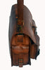 A distressed brown leather messenger bag with a vintage look, sitting on a rustic wooden floor.