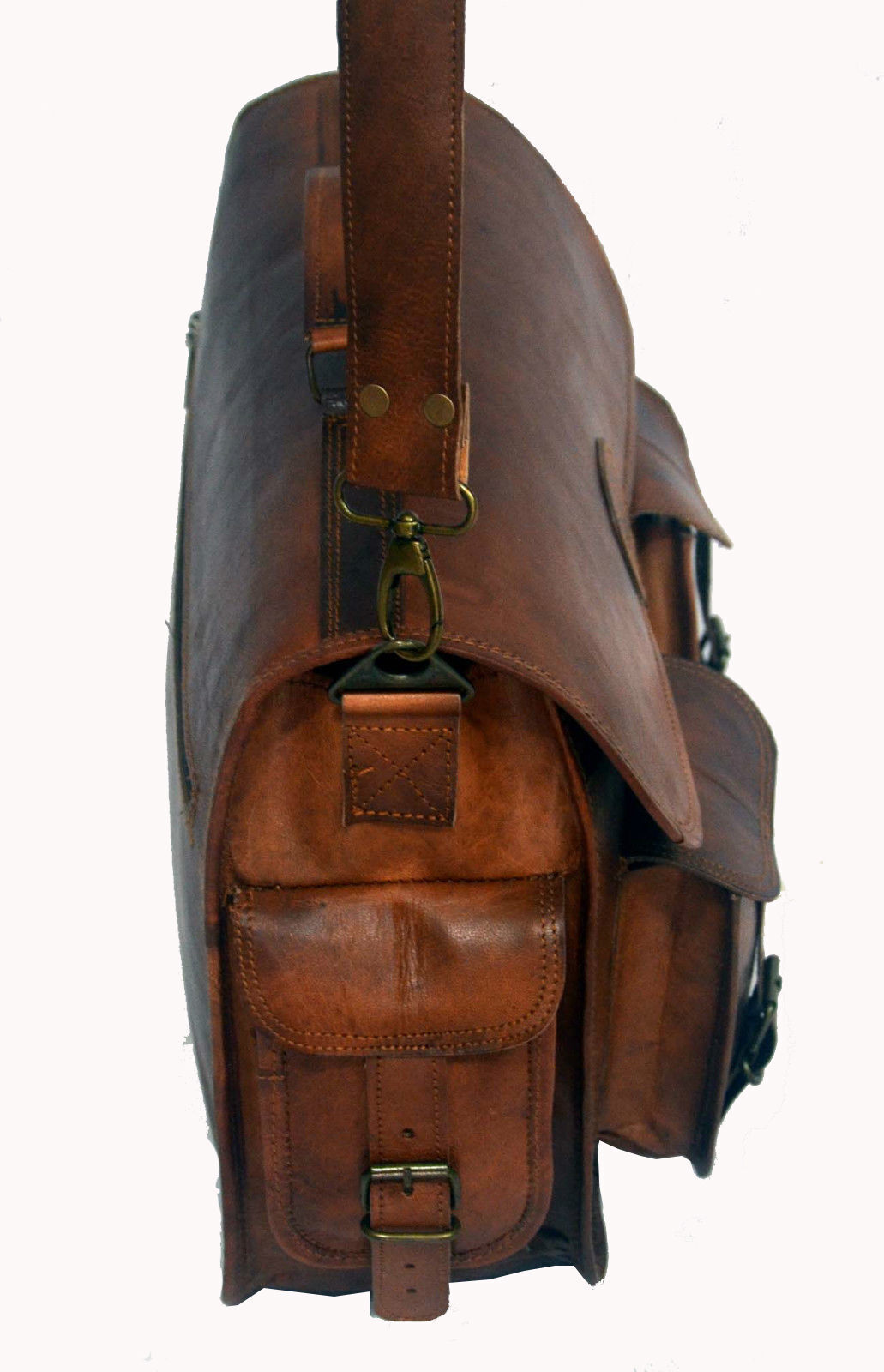 A distressed brown leather messenger bag with a vintage look, sitting on a rustic wooden floor.