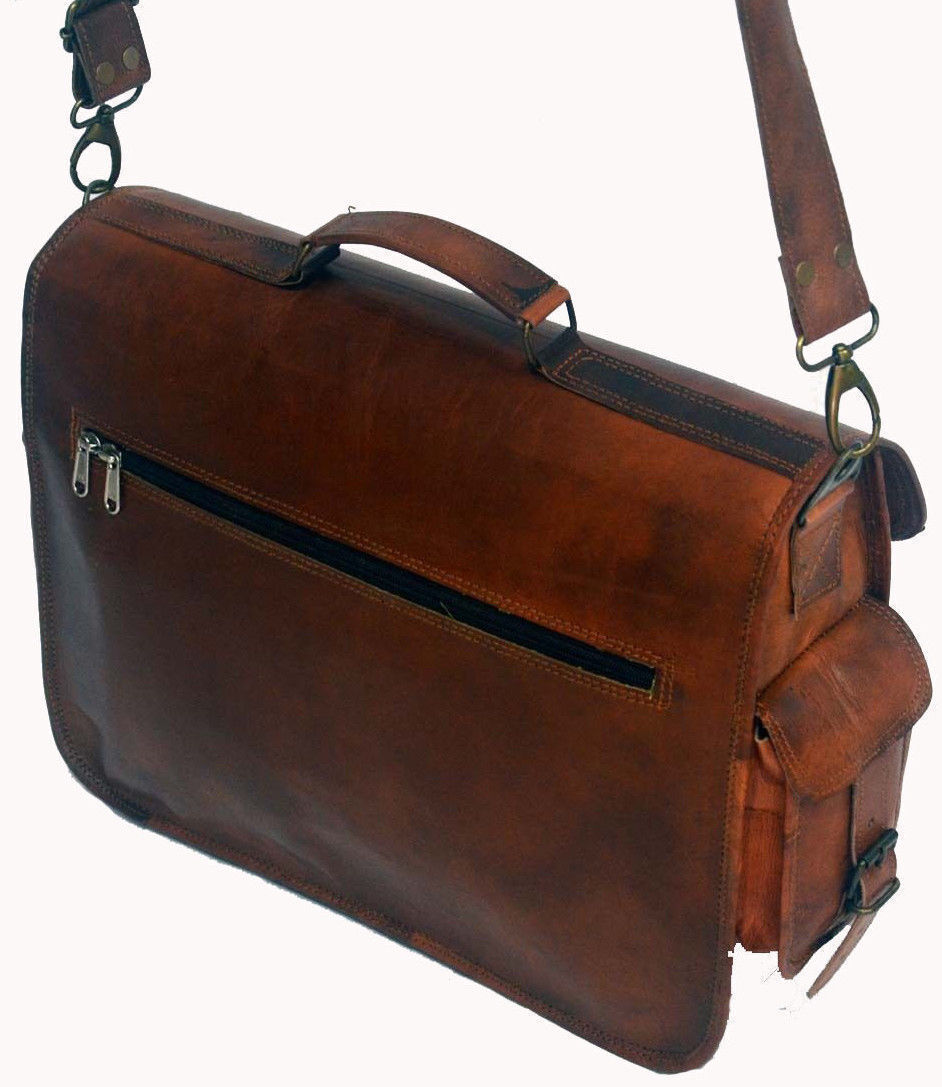 Distressed leather messenger bag with a worn finish, hanging on a metal hook against a brick wall.