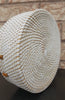 Versatile rattan purse handbag with intricate weaving, leather strap, and compact shape, showcased on a rustic table.