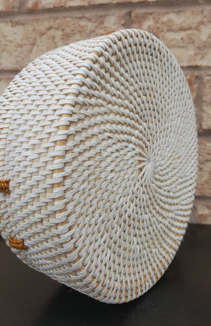 Versatile rattan purse handbag with intricate weaving, leather strap, and compact shape, showcased on a rustic table.