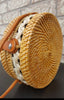Chic rattan handbags displayed on a rustic wooden surface, highlighting their intricate woven patterns and elegance.