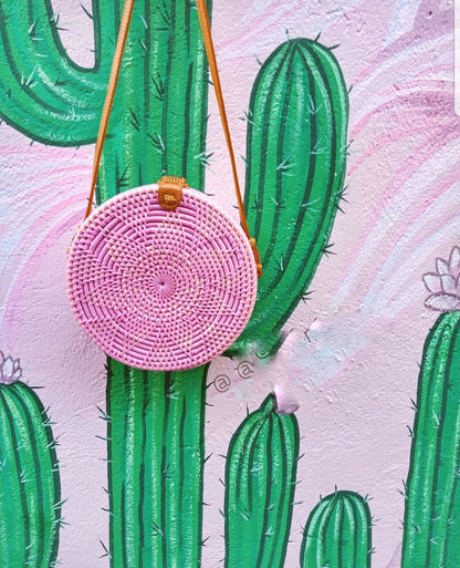 Beautiful round rattan bag with intricate weaving and leather strap.