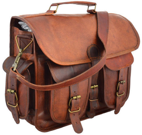 A rugged brown leather messenger bag for men with a durable strap, displayed on a wooden bench outdoors.
