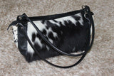 This shoulder bag is made from real cowhide and it is black and white. It is a great addition to any outfit and it will make you look more stylish. The bag is also very spacious and it can hold all your essentials.